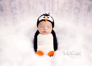 Baby dressed in knit penguin outfit